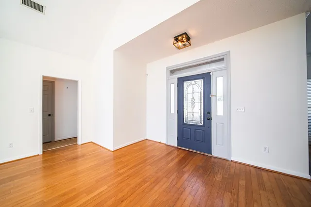 a view of empty room with wooden floor