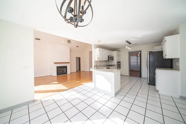 a large white kitchen with a sink and a stove top oven