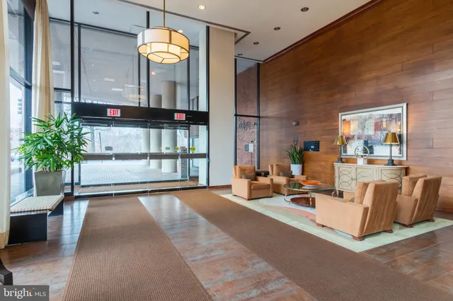 a living room with furniture a chandelier and a large window