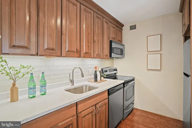 a kitchen with stainless steel appliances granite countertop a sink a stove and cabinets
