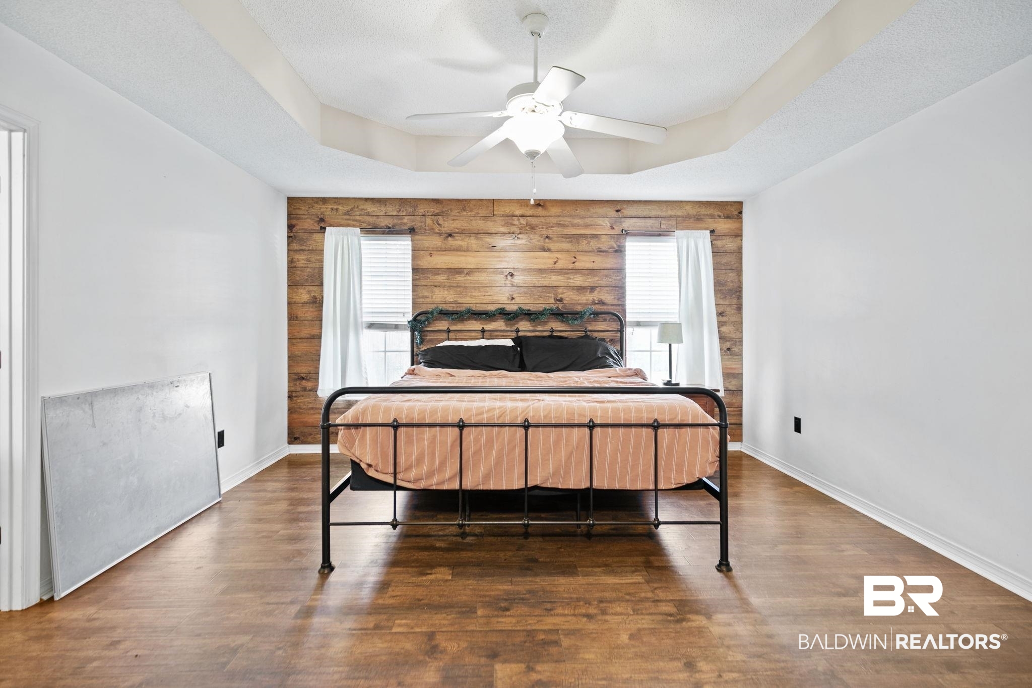 10550 Patrick Avenue Grand Bay, AL 36541 - Photo 22 of 43 Bedroom with a textured ceiling, a raised ceiling, hardwood / wood-style floors, and ceiling fan