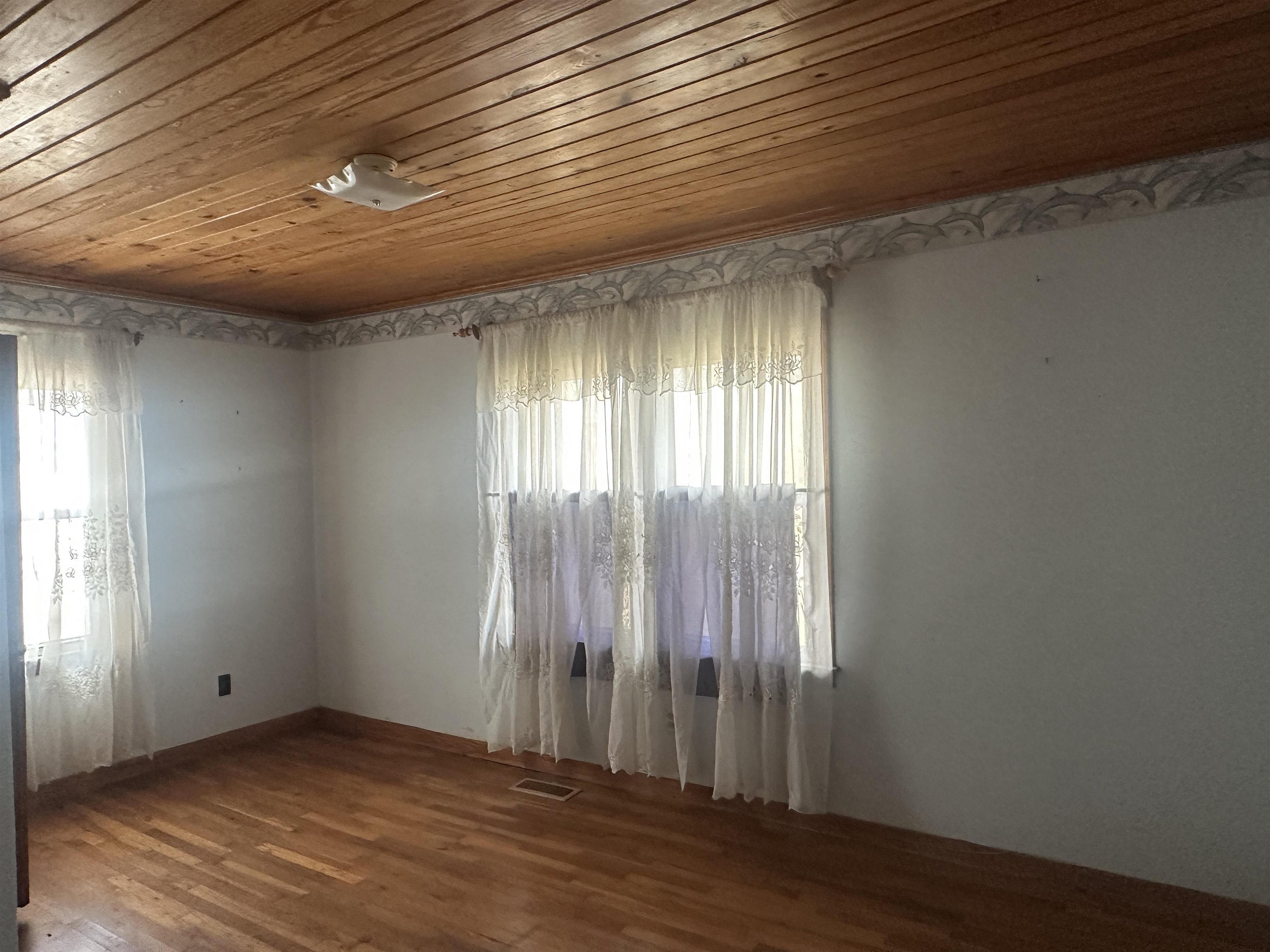 123 North Magnolia Street Adamsville, TN 38310 - Photo 18 of 25 an empty room with wooden floor and windows