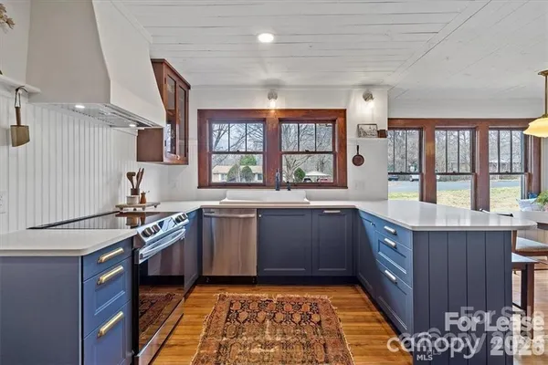 a kitchen with stainless steel appliances granite countertop a sink stove and cabinets