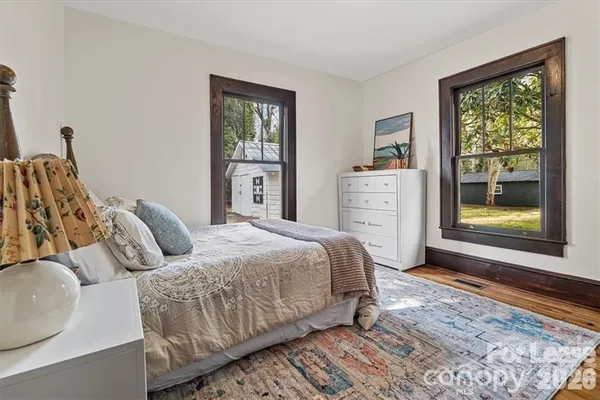 a bedroom with a bed and wooden floor