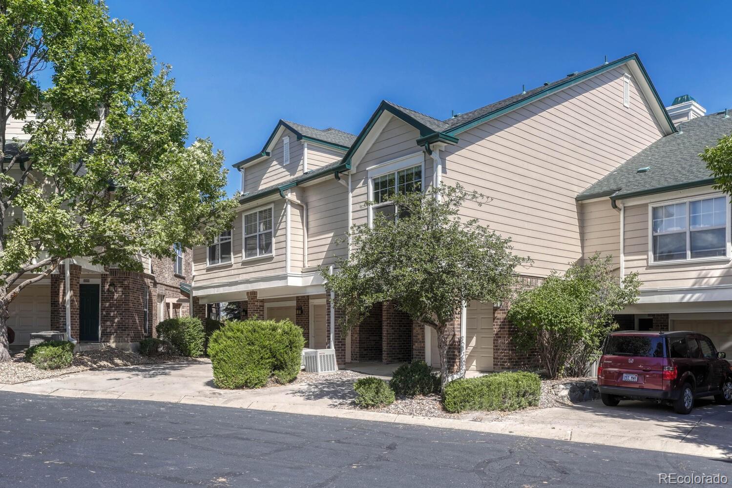a red car parked in front of a white house