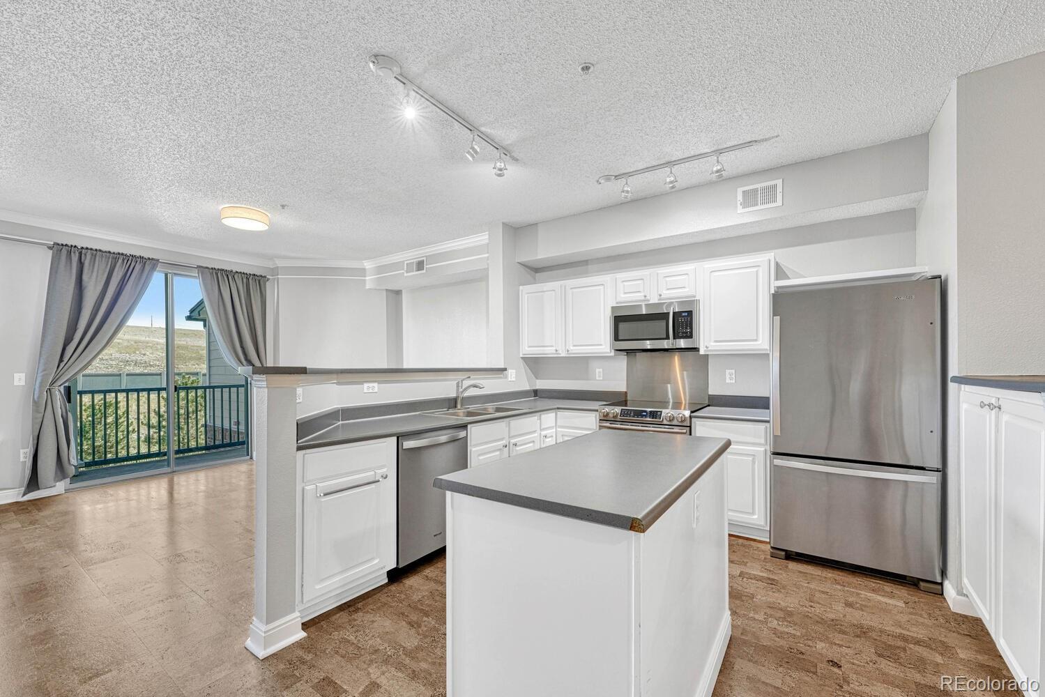 2149 Eagle Avenue Superior, CO 80027 - Photo 10 of 31 a kitchen with kitchen island a counter top space a large window appliances and cabinets