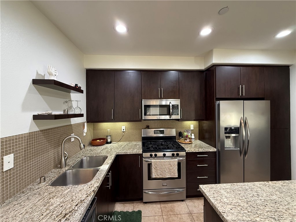 2230 Indus Way San Marcos, CA 92078 - Photo 8 of 26 a kitchen with granite countertop a refrigerator and a sink