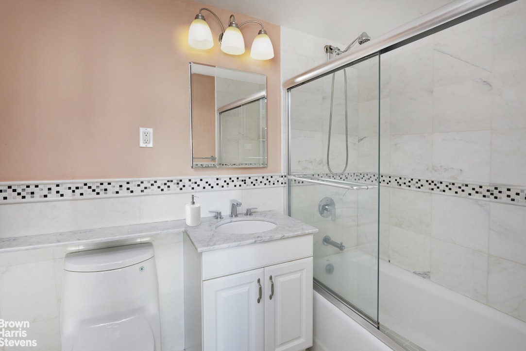 460 East 79th Street, Unit 16A Manhattan, NY 10075 - Photo 11 of 20 a bathroom with a sink a toilet and shower