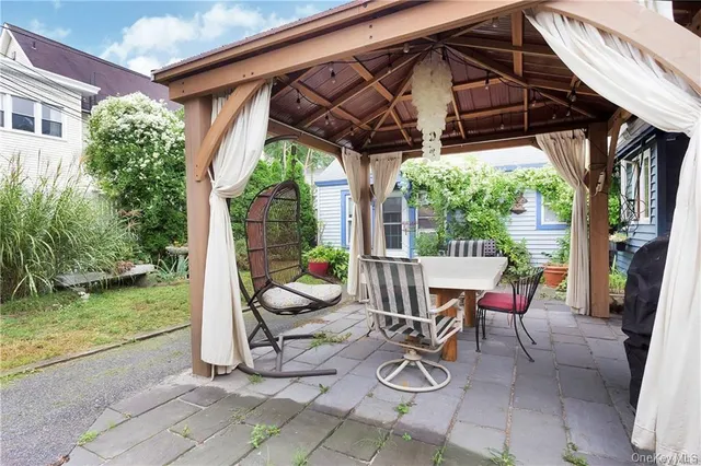 a view of a patio with table and chairs under an umbrella