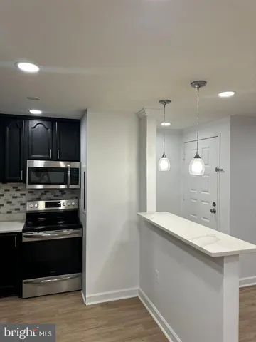 a kitchen with stainless steel appliances kitchen island granite countertop a stove a sink and a refrigerator