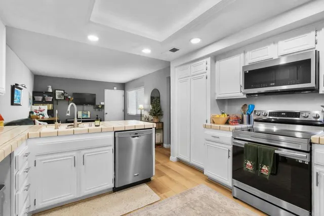 a kitchen with white cabinets and stainless steel appliances