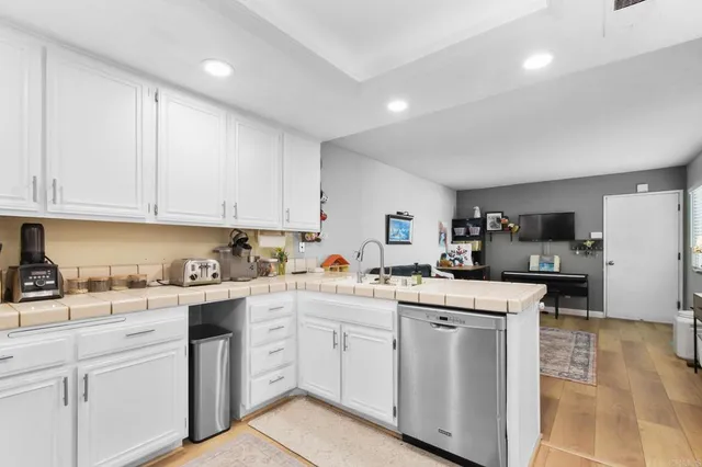 a kitchen with white cabinets and sink