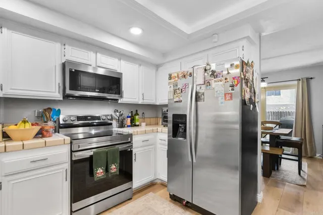 a kitchen with stainless steel appliances granite countertop a refrigerator a stove top oven a sink and dishwasher