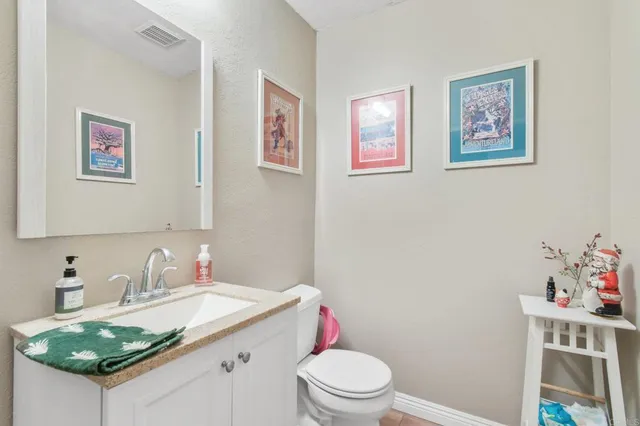 a bathroom with a granite countertop sink mirror vanity and toilet