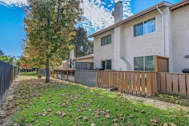 a white house that has tree in front of it