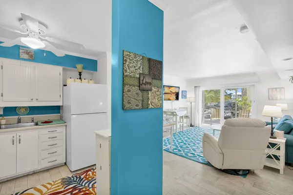 a living room with furniture and a refrigerator