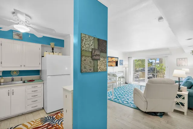 a living room with furniture and a refrigerator
