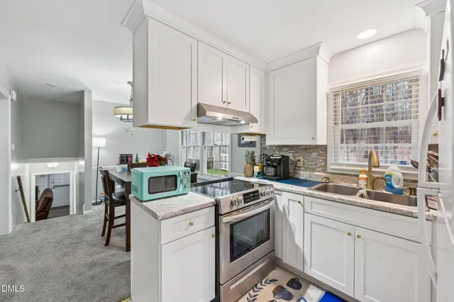a kitchen with white cabinets and white appliances