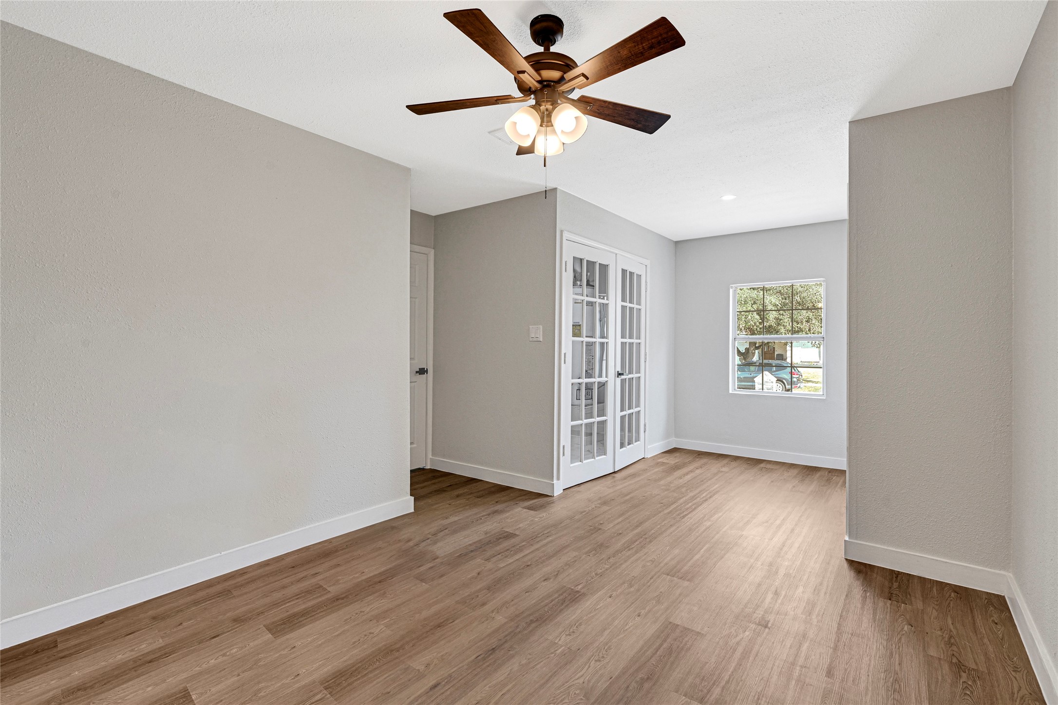 5213 Shirley Street Baytown, TX 77521 - Photo 11 of 12 an empty room with wooden floor chandelier fan and windows