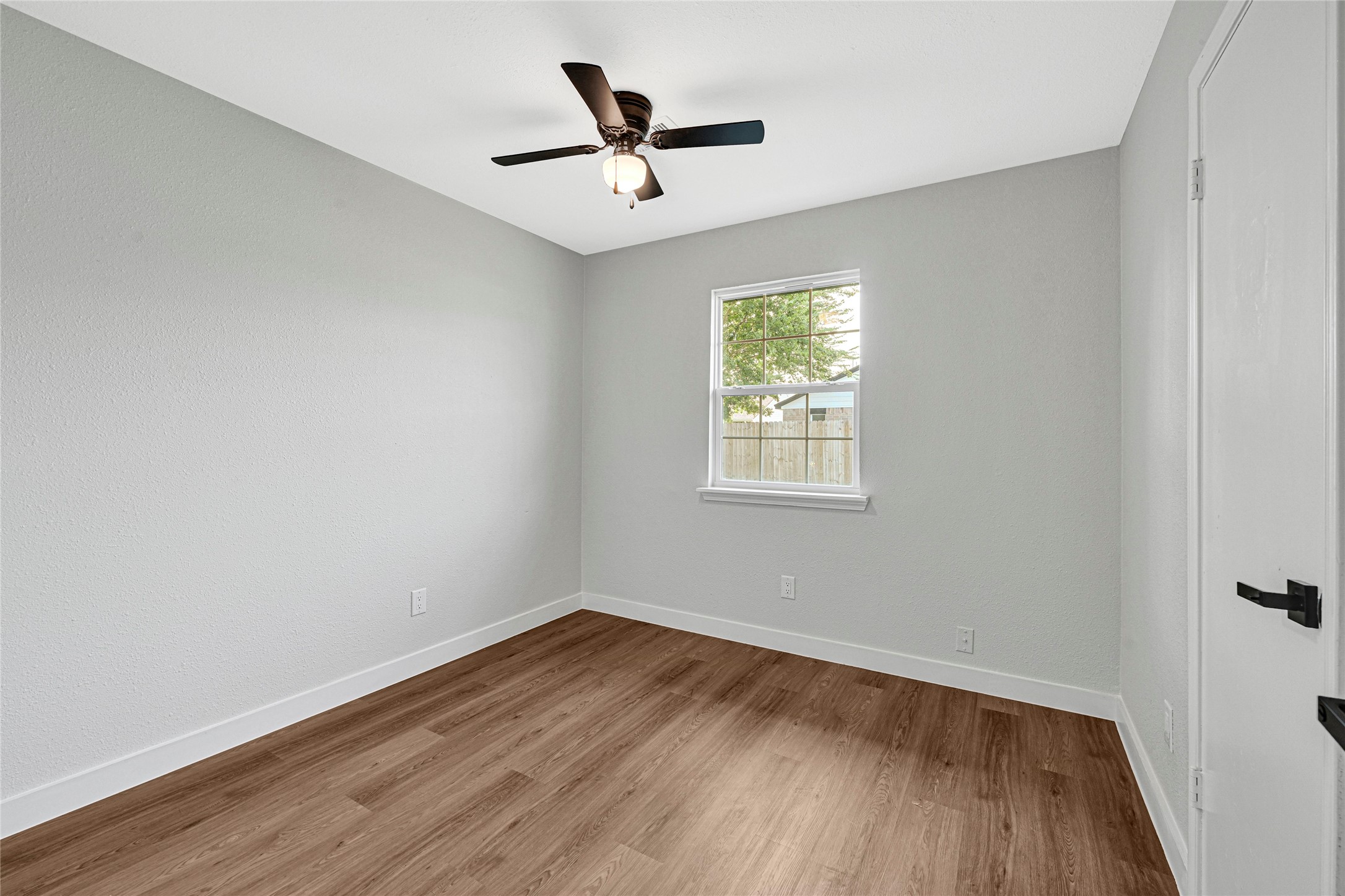 5213 Shirley Street Baytown, TX 77521 - Photo 3 of 12 an empty room with wooden floor and ceiling fan