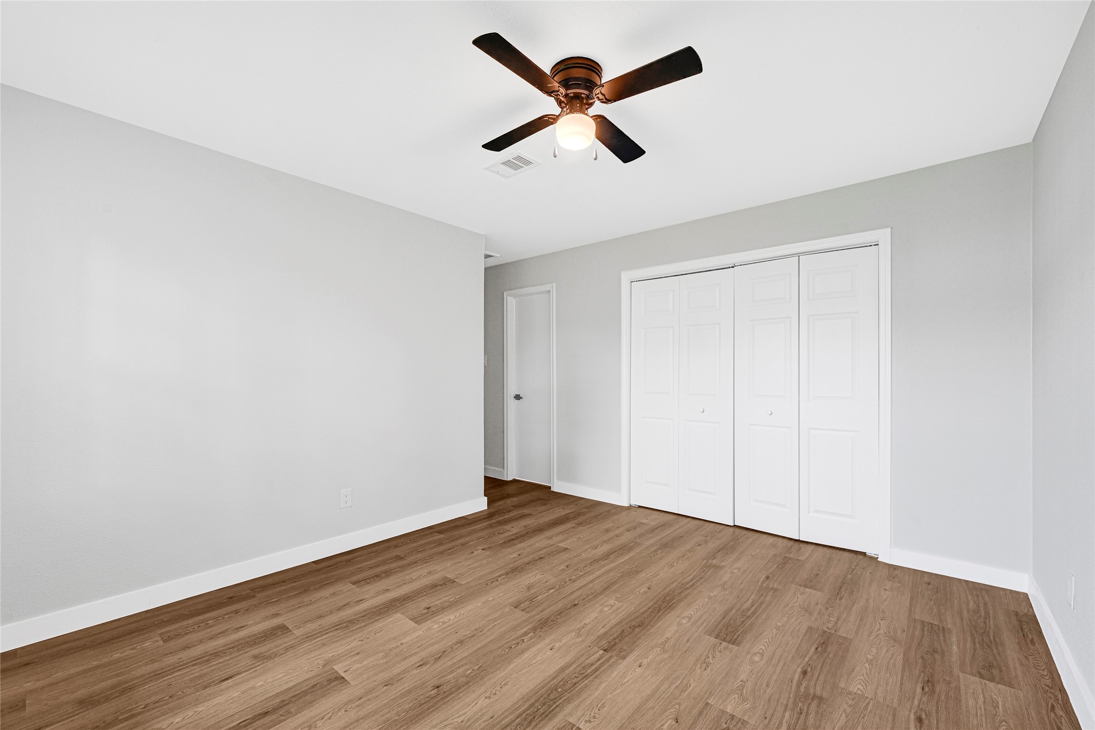 5213 Shirley Street Baytown, TX 77521 - Photo 5 of 12 an empty room with wooden floor and ceiling fan