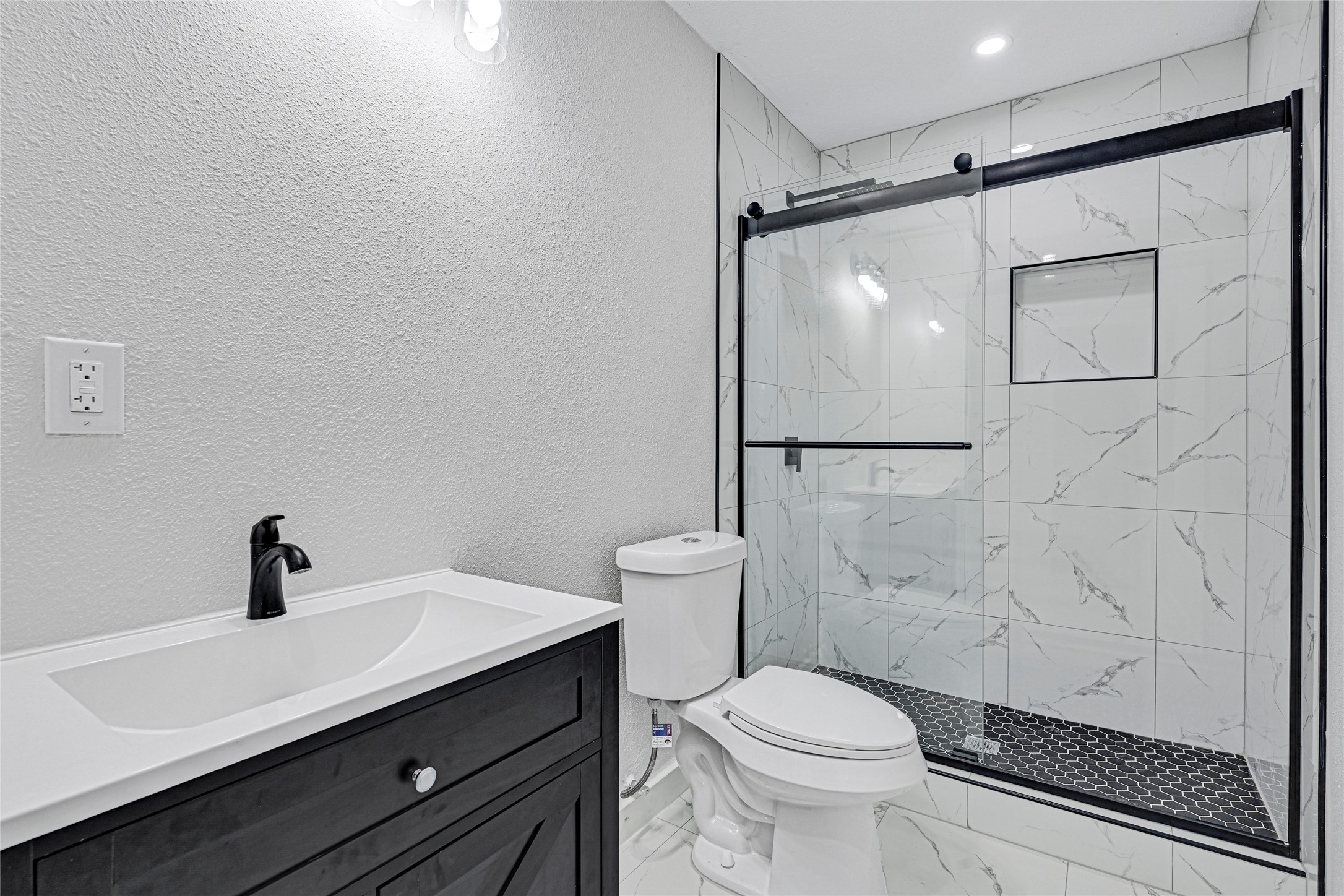5213 Shirley Street Baytown, TX 77521 - Photo 6 of 12 a bathroom with a sink a toilet a mirror and shower