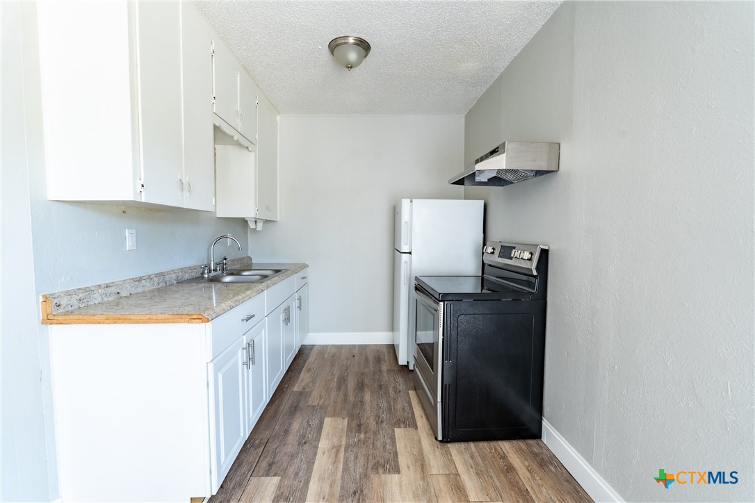512 Sunset Lane, Unit AD Copperas Cove, TX 76522 - Photo 6 of 23 a kitchen with granite countertop a refrigerator a stove top oven a sink and dishwasher