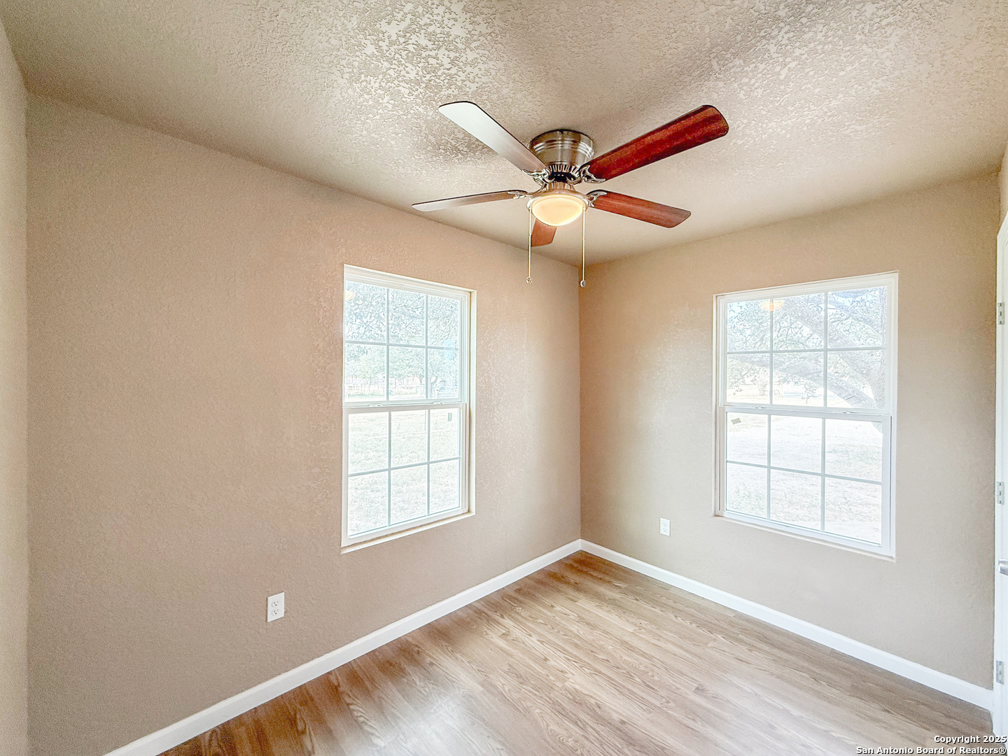 303 Davis Avenue Devine, TX 78016 - Photo 12 of 16 a view of empty room with wooden floor and fan