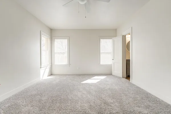an empty room with windows and closet
