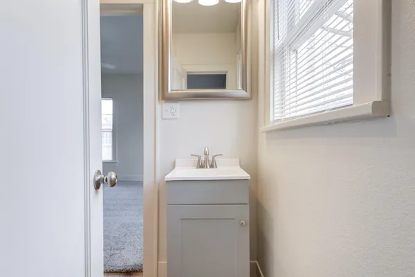 a bathroom with a sink a mirror and a window