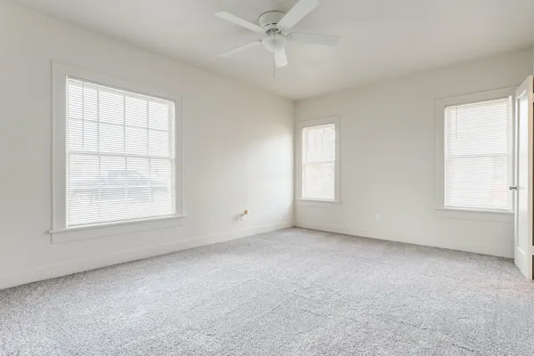 an empty room with a window and a kitchen
