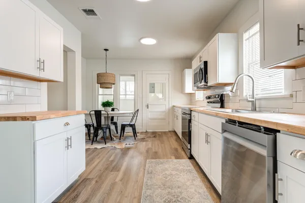 a kitchen with cabinets a sink a counter space and stainless steel appliances