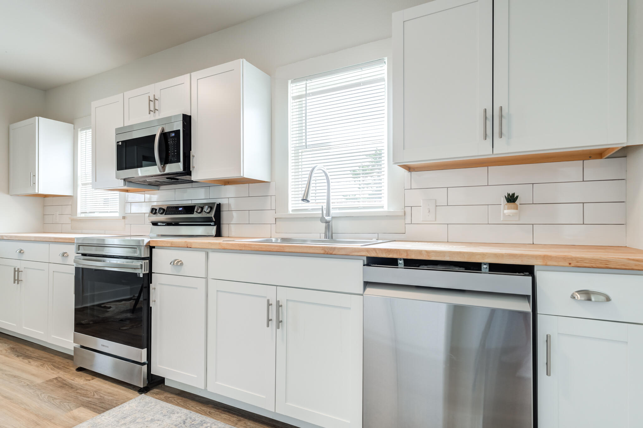 1721 23rd Street Lubbock, TX 79411 - Photo 9 of 29 a kitchen with stainless steel appliances granite countertop a sink a stove a microwave and cabinets