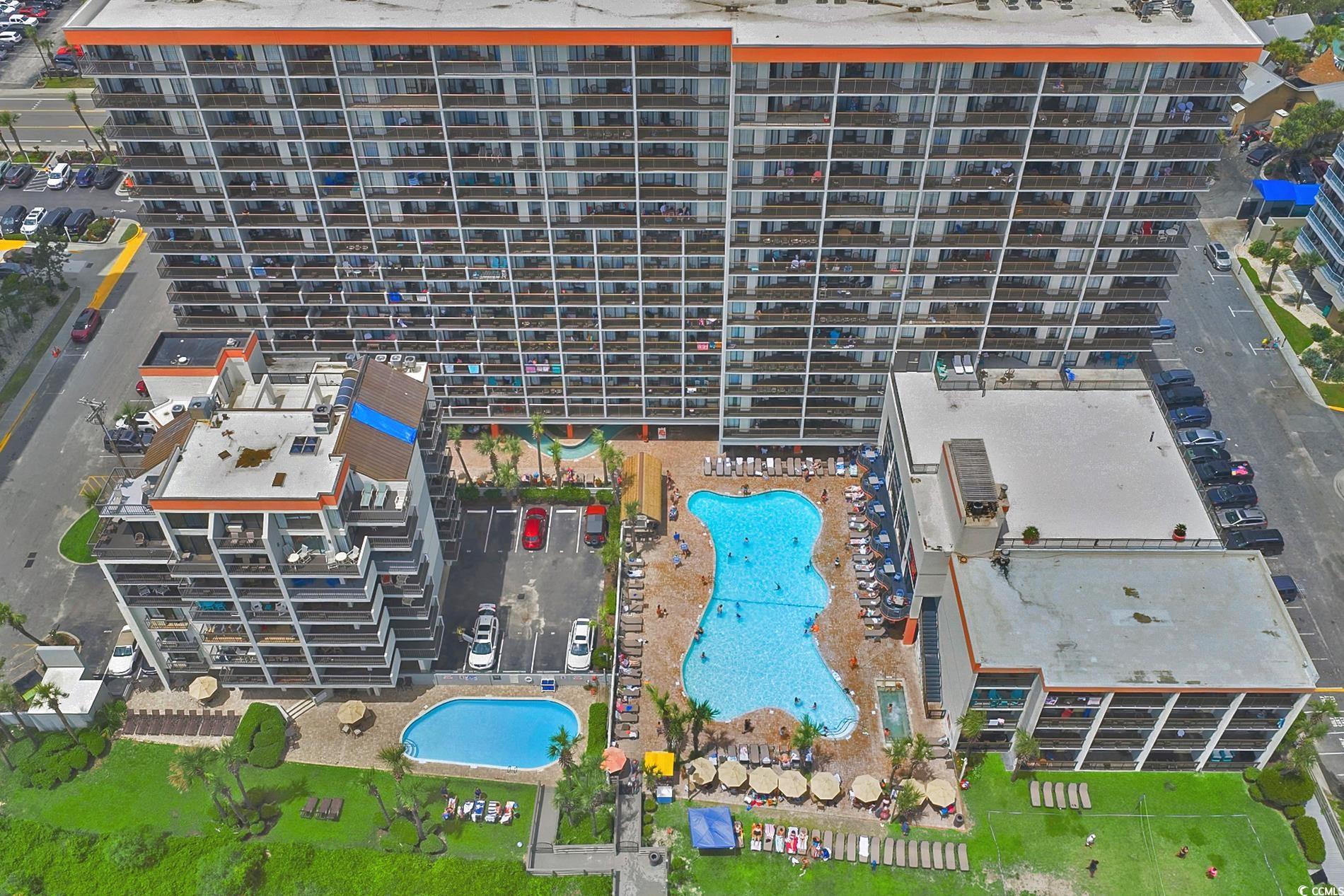 Drone / aerial view of apartment complex / building and a pool area