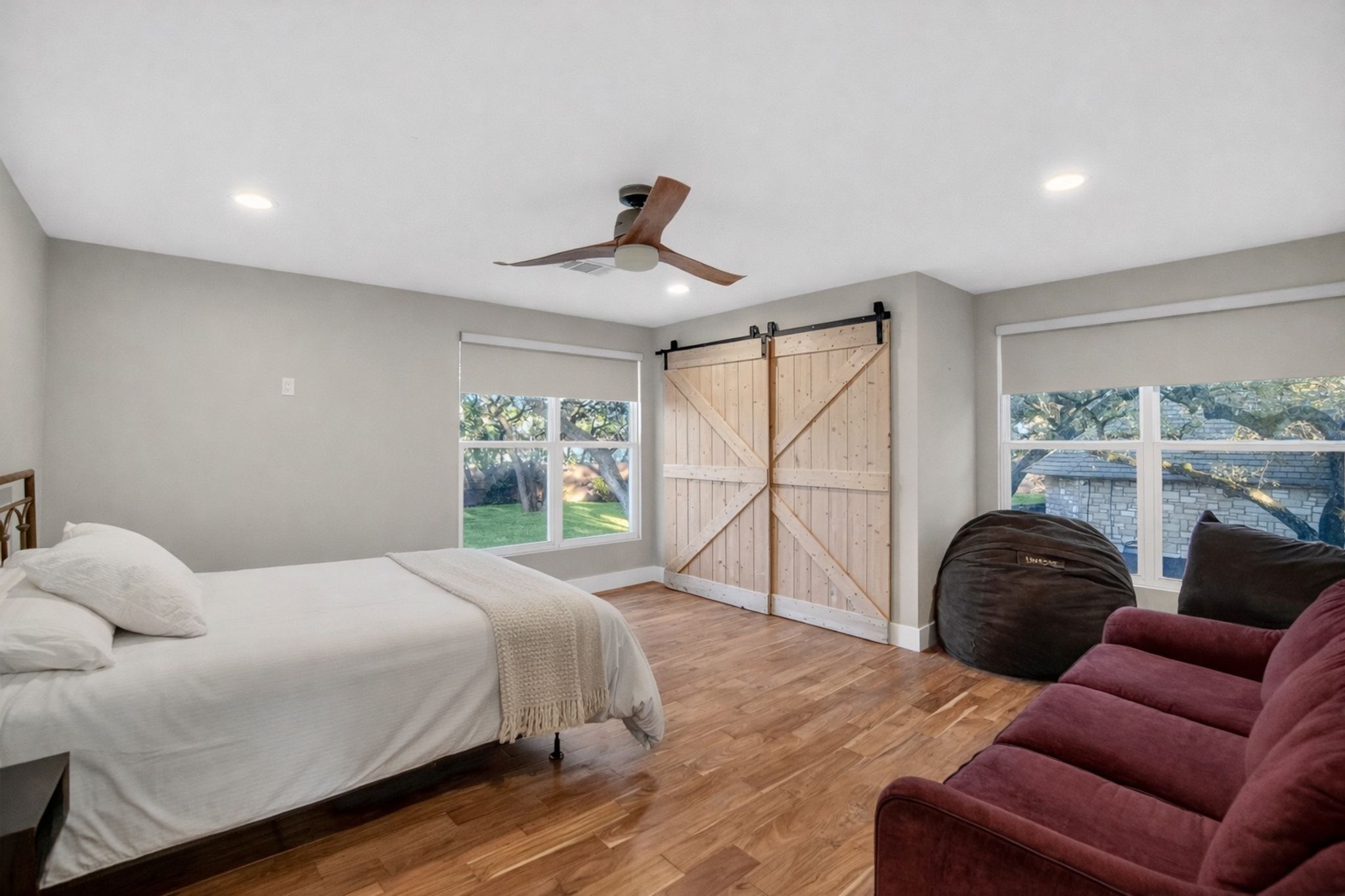 3627 Stoneridge Road Austin, TX 78746 - Photo 33 of 40 Bedroom with a barn door, light wood finished floors, ceiling fan, and recessed lighting