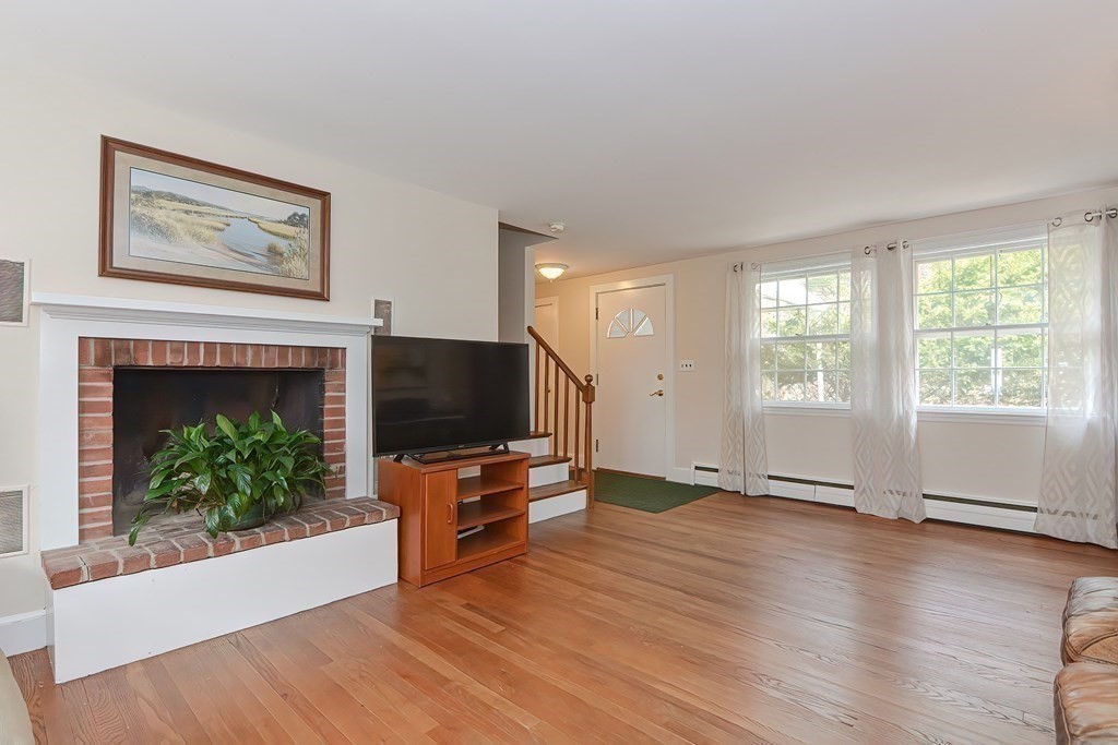 a view of empty room with wooden floor and fireplace
