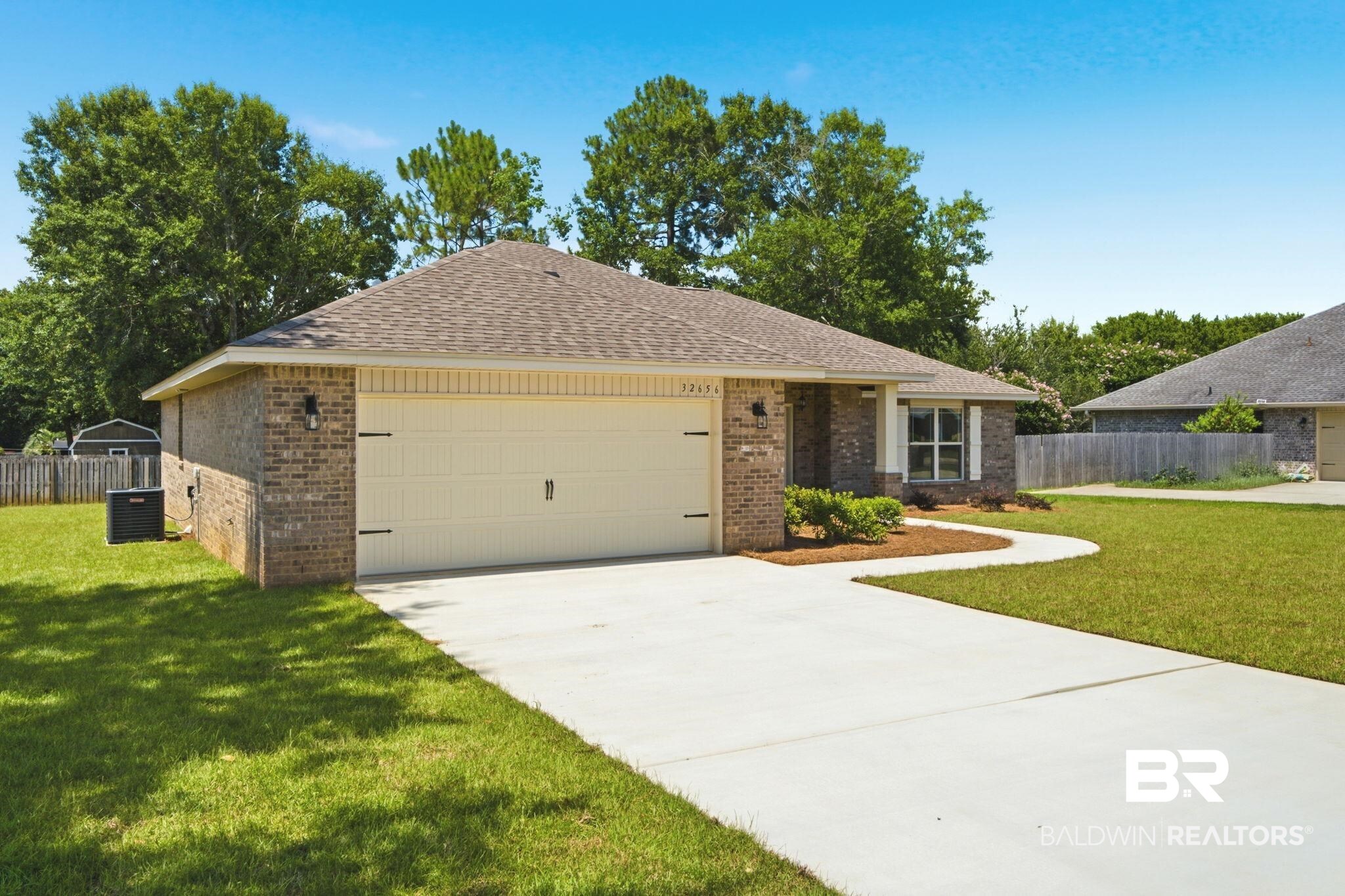 32656 Arbor Ridge Circle Lillian, AL 36549 - Photo 55 of 56 Brick exterior featuring a two-car garage with decorative hardware, a concrete driveway, and a front walkway