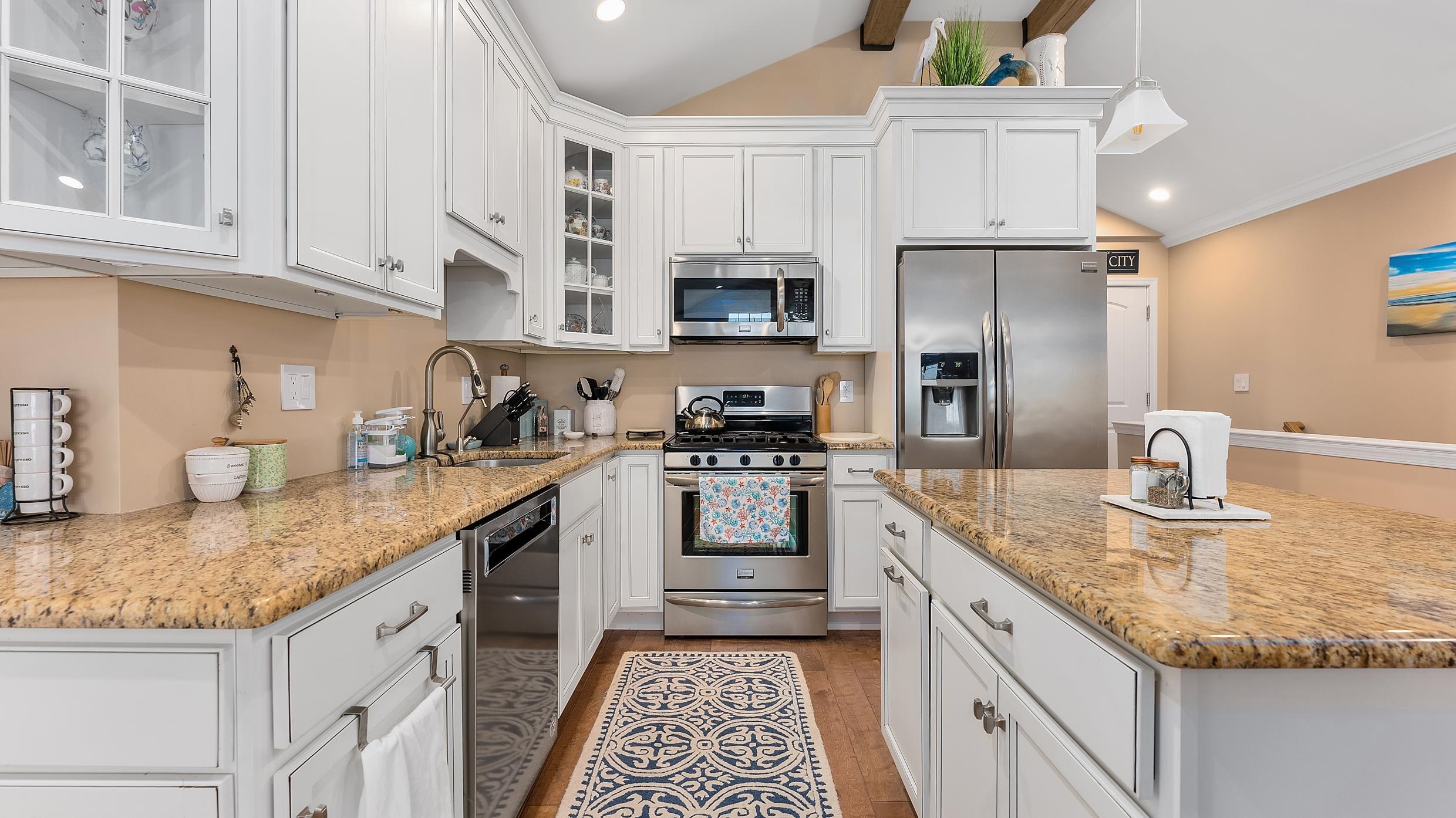 4477 Venicean Road, Unit SOUTH Sea Isle City, NJ 08243 - Photo 4 of 36 a kitchen with granite countertop a sink stainless steel appliances and white cabinets