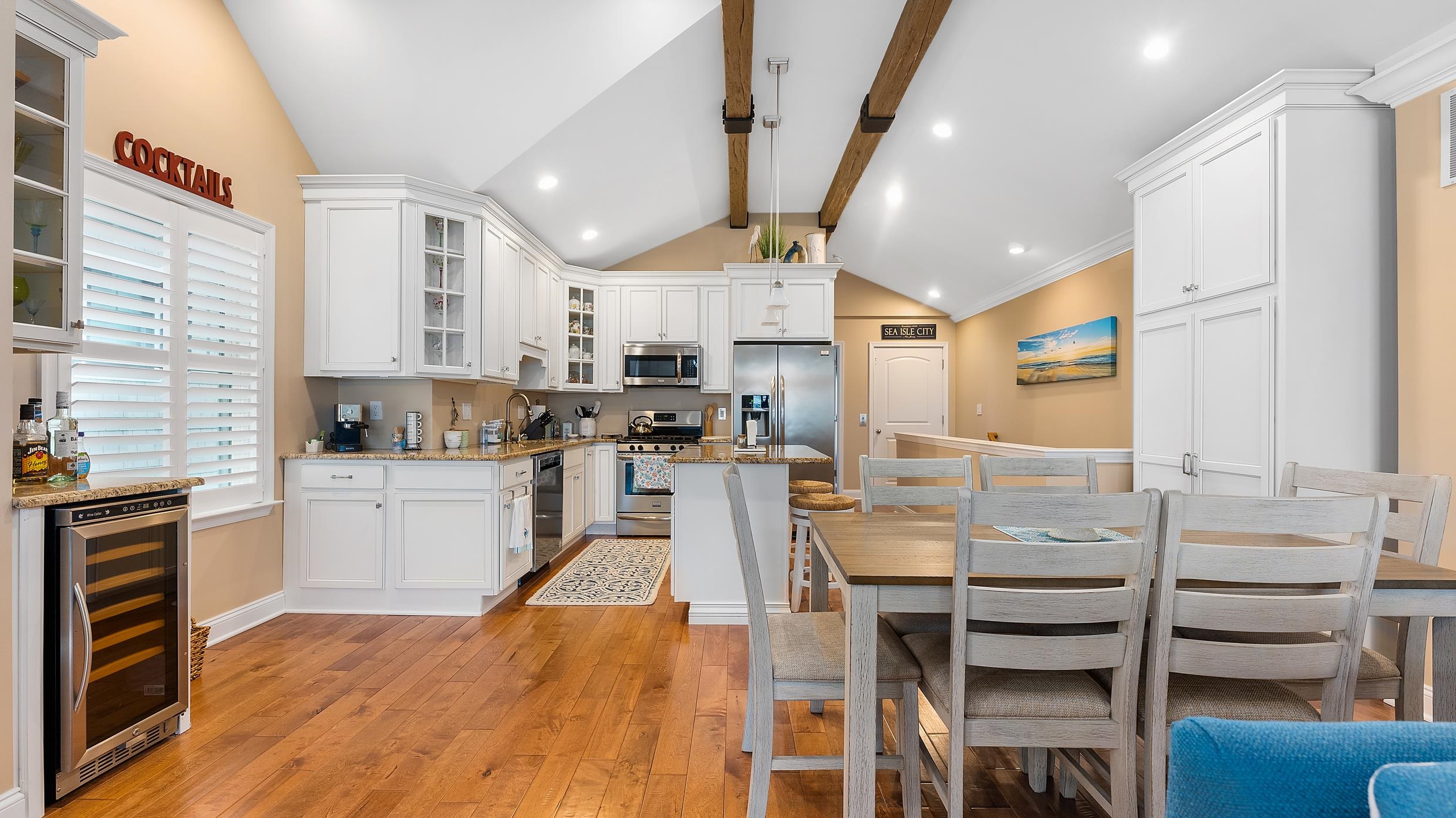 4477 Venicean Road, Unit SOUTH Sea Isle City, NJ 08243 - Photo 6 of 36 a kitchen with stainless steel appliances kitchen island granite countertop a stove top oven a sink dishwasher and white cabinets with wooden floor