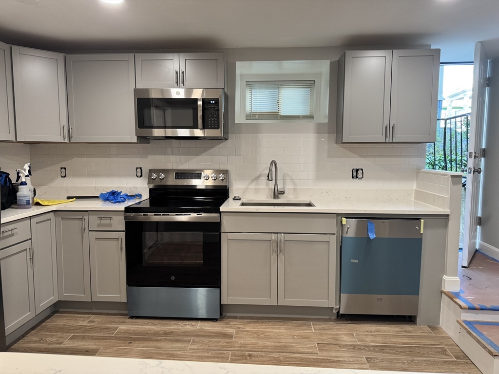 a kitchen with a sink stove and microwave