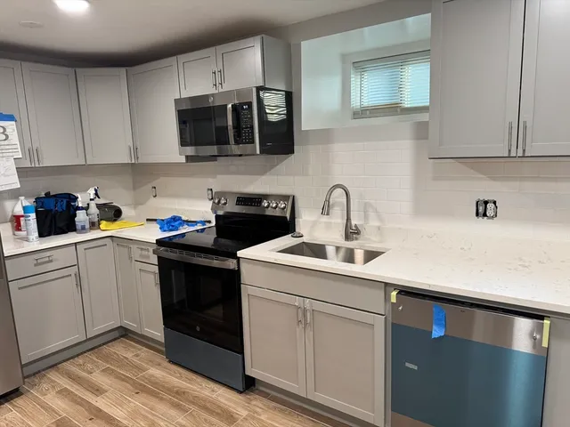 a kitchen with stainless steel appliances a sink dishwasher a stove microwave and cabinets