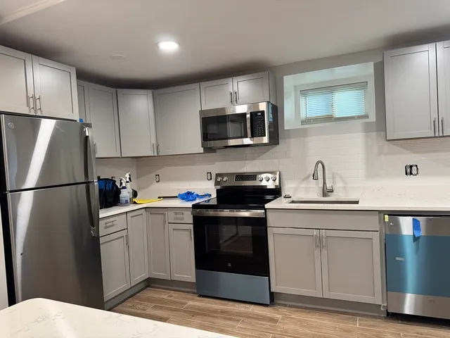 a kitchen with cabinets stainless steel appliances and sink
