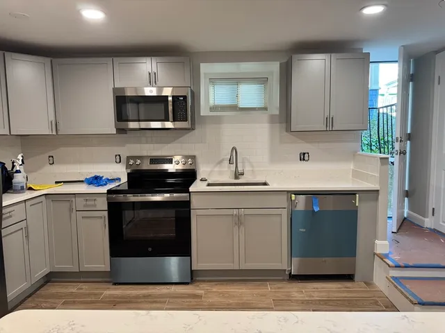 a kitchen with stainless steel appliances granite countertop a stove a sink and a microwave