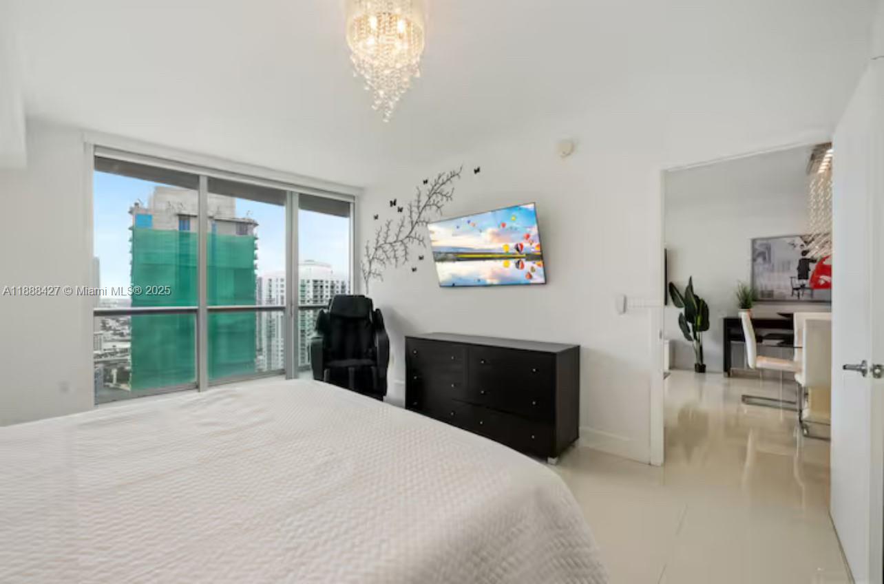 485 Brickell Avenue, Unit 3707 Miami, FL 33131 - Photo 13 of 41 a bedroom with a bed and a chandelier