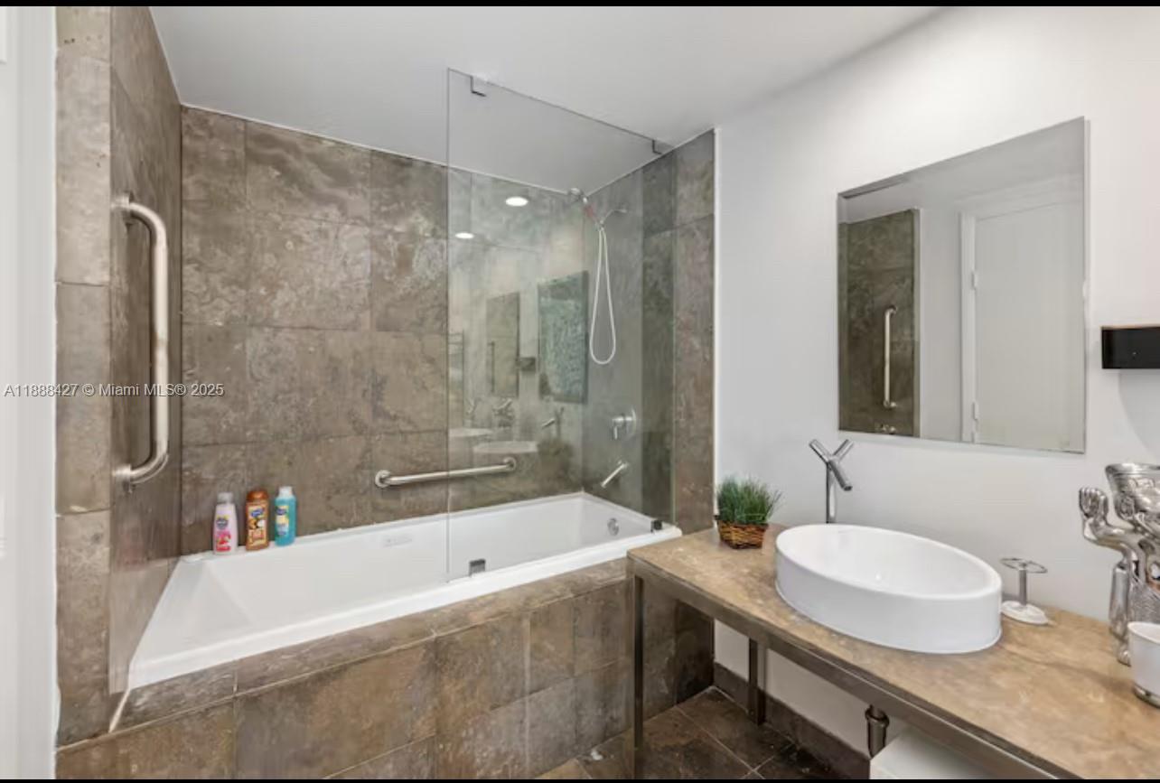 485 Brickell Avenue, Unit 3707 Miami, FL 33131 - Photo 10 of 41 a bathroom with a granite countertop tub sink and mirror