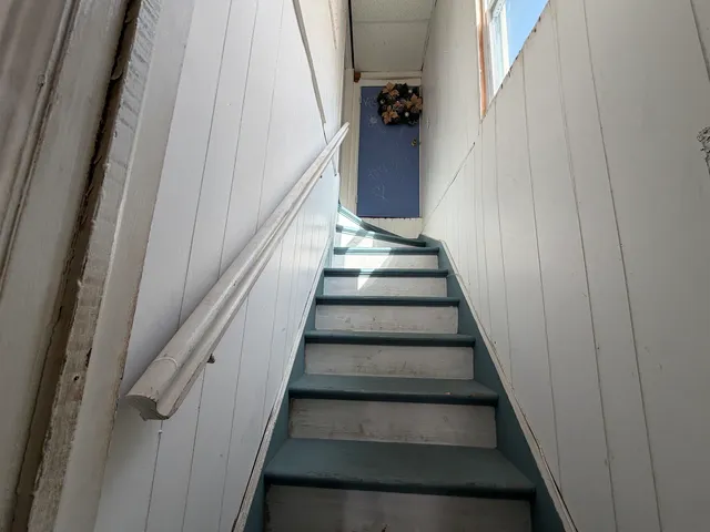 a view of staircase with white walls and windows