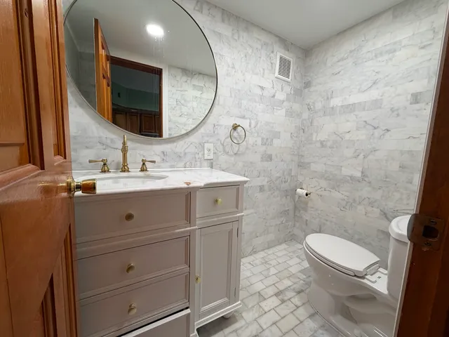 a bathroom with a double vanity sink mirror and toilet