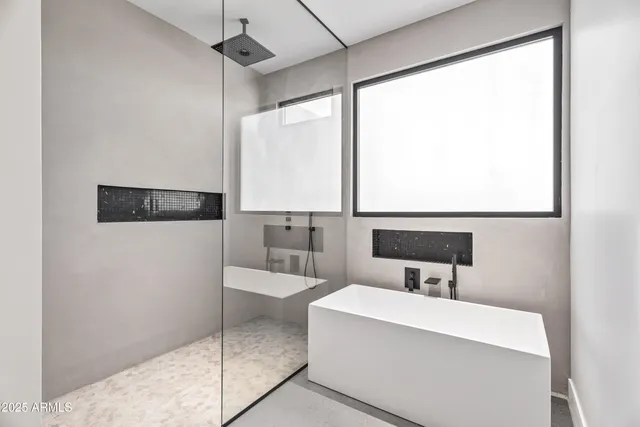 a bathroom with a tub sink and mirror