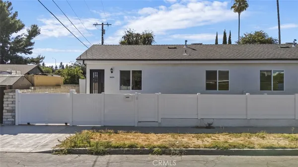 a view of a house with a wooden fence