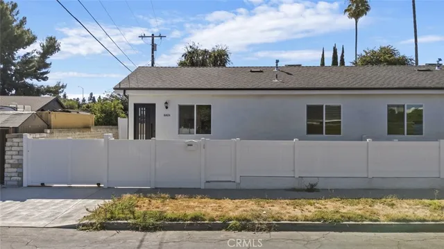 a view of a house with a wooden fence